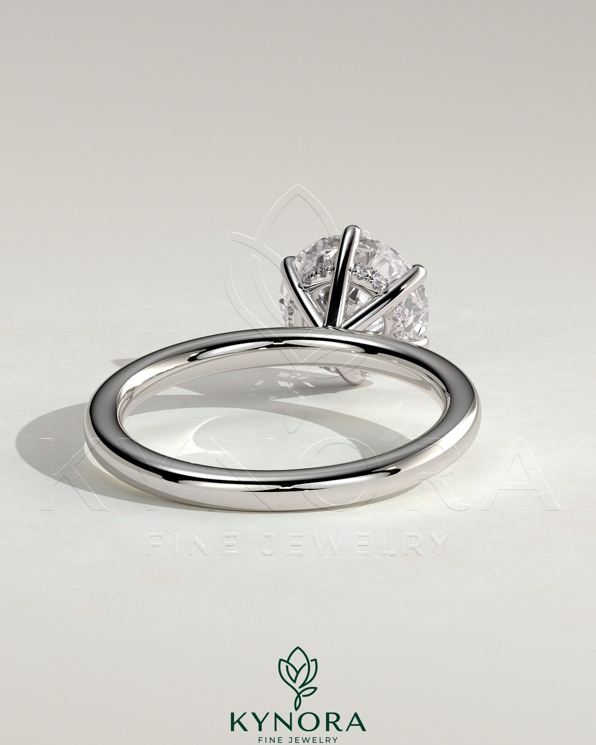 Kynora CJ 2ct round claw solitaire engagement ring with hidden halo and sparkling diamond accents on a sleek band.
