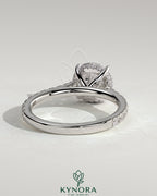 Kynora CJ 2ct round claw solitaire engagement ring with hidden halo, pave band, and cathedral high setting.