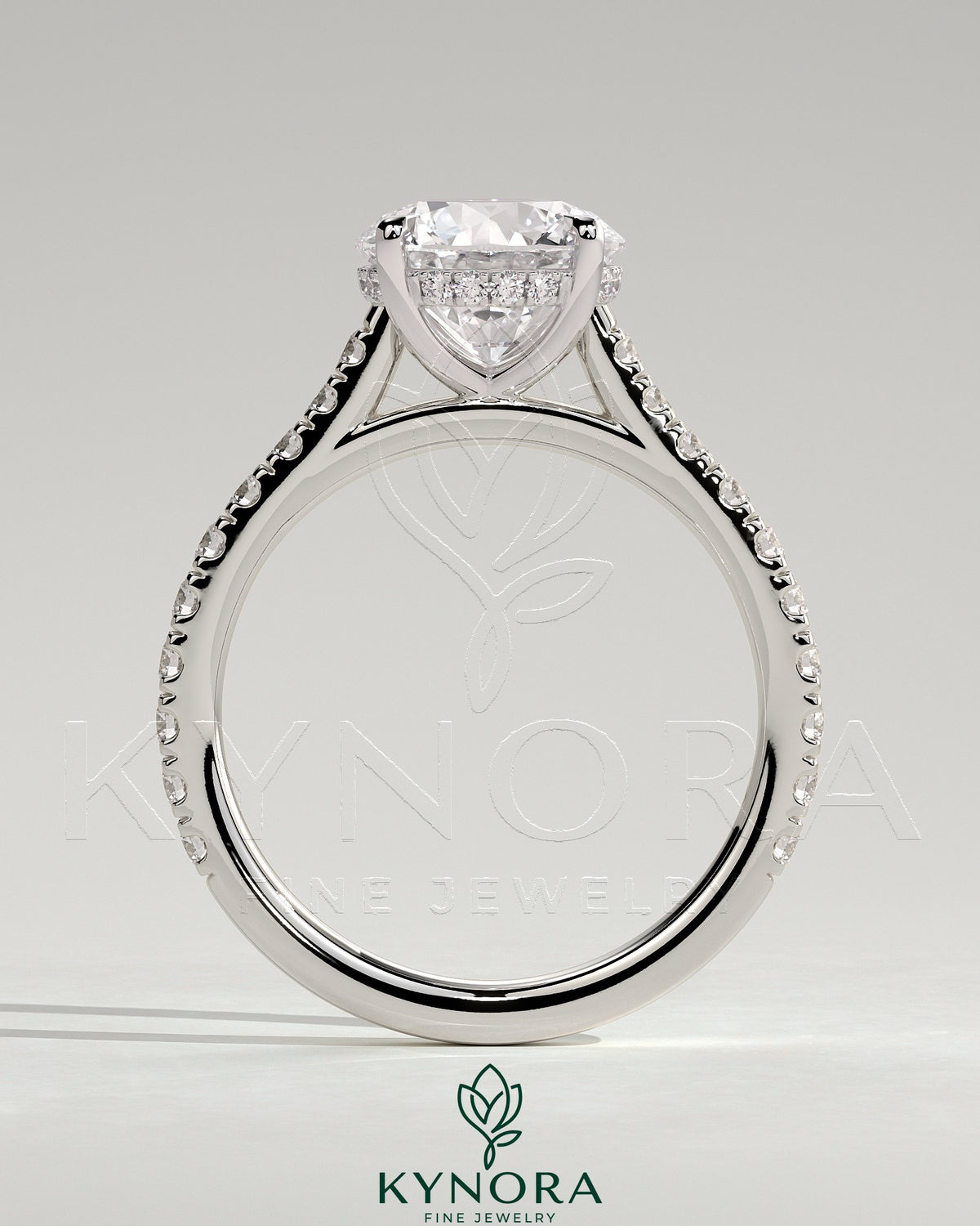 Kynora CJ 2ct round claw solitaire engagement ring with hidden halo, pave band, and cathedral high setting showcasing intricate design.
