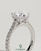 Kynora CJ 2ct round claw solitaire engagement ring with hidden halo, pavé band, and cathedral high setting.