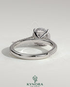 Kynora CJ 2ct round claw solitaire engagement ring with hidden halo, triple pave band, and cathedral high setting.