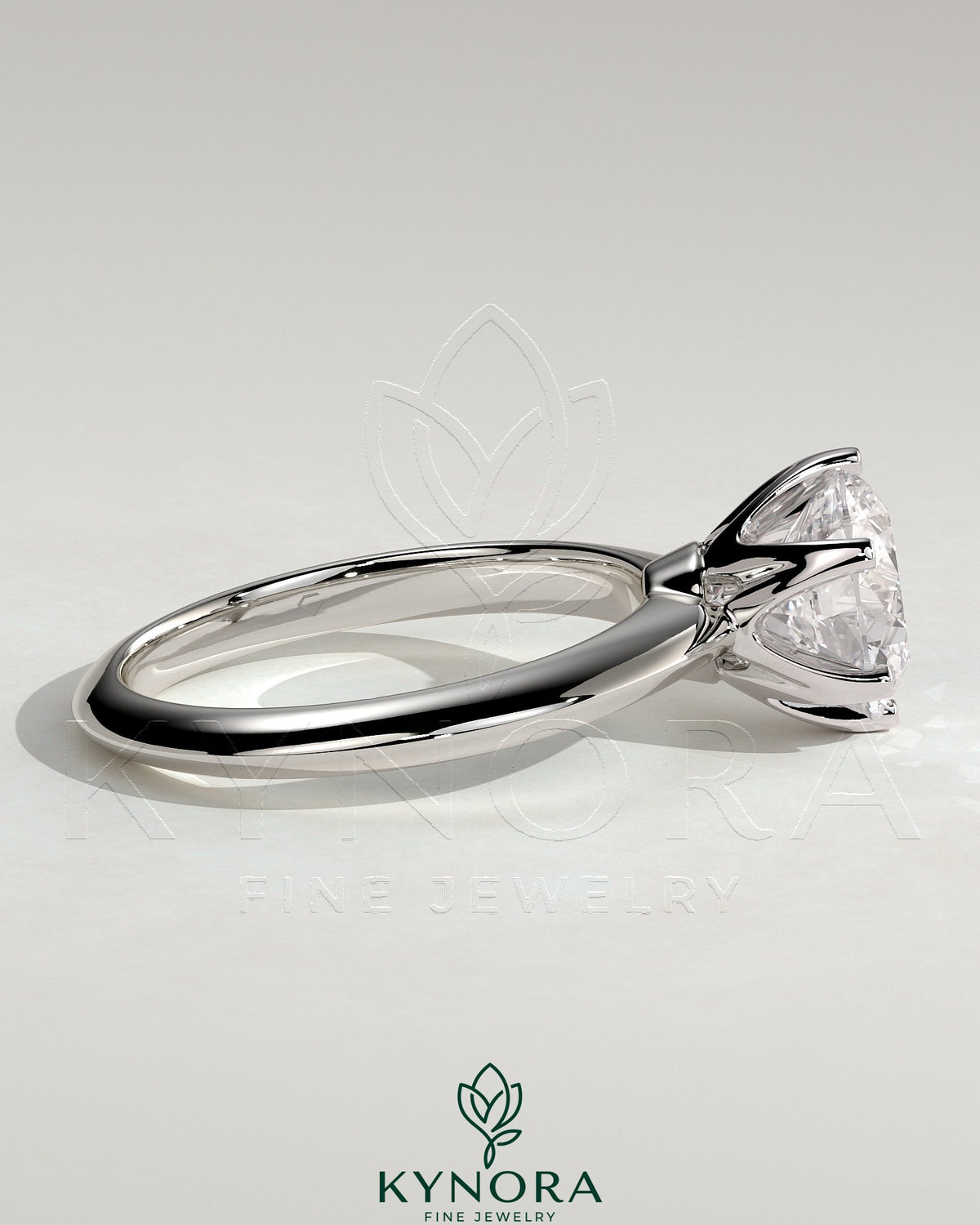 Kynora CJ 2ct round claw solitaire engagement ring with knife edge band, showcasing a sparkling central diamond in elegant jewelry design.