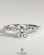 Kynora CJ 2ct round claw solitaire engagement ring with marquise and round accent stones, elegant and sparkling jewelry piece.
