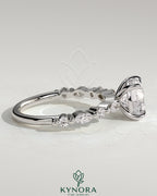 Kynora CJ 2ct round claw solitaire engagement ring with marquise and round accent stones, showcasing elegant jewelry craftsmanship.