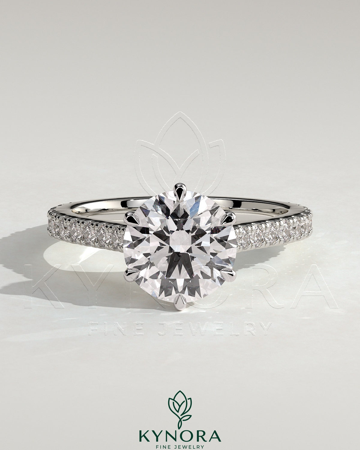 Kynora CJ 2ct round claw solitaire engagement ring with pave band and cathedral high setting, showcasing sparkling diamond details.