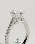 Kynora CJ 2ct round diamond solitaire engagement ring with pave band and cathedral high setting, showcasing elegant jewelry design.