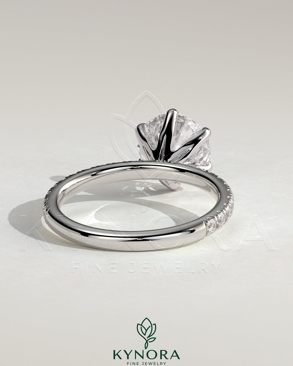 Kynora CJ 2ct round claw solitaire engagement ring with pavé band showcasing a sparkling center diamond and intricate band details.