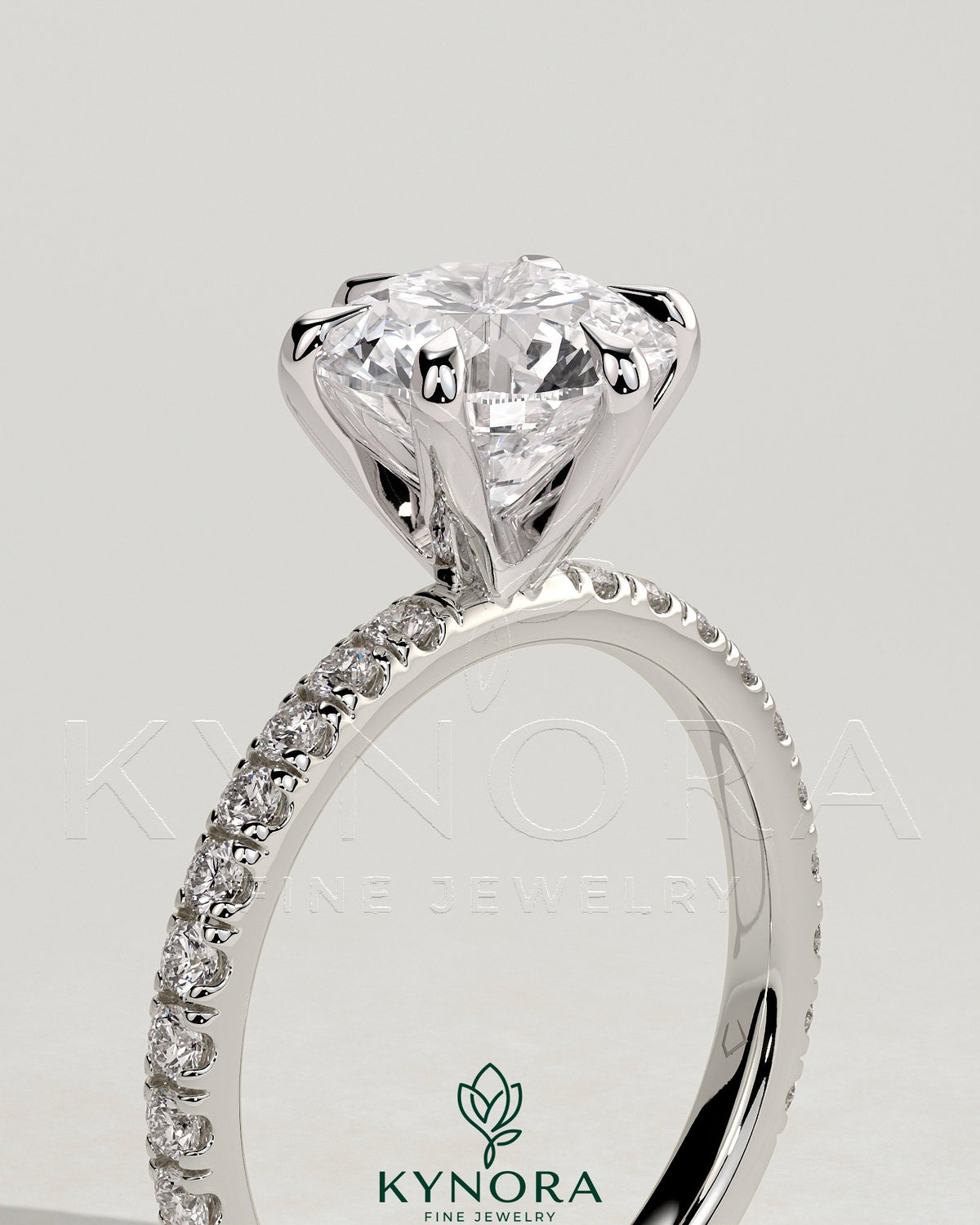 Kynora CJ 2ct round claw solitaire engagement ring with pave band, showcasing elegant diamond setting and detailed craftsmanship.