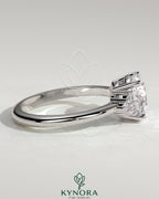 Kynora CJ 2-carat round claw solitaire engagement ring with round shoulder stones, featuring a sparkling central gemstone.