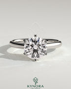Kynora CJ 2ct round claw solitaire engagement ring with square tips and high cathedral setting, showcasing elegant jewelry craftsmanship.