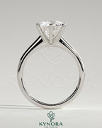 Kynora CJ 2ct round claw solitaire engagement ring with square tips and cathedral high setting, crafted in elegant jewelry style.