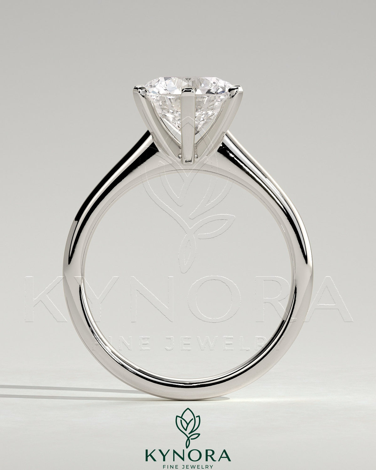 Kynora CJ 2ct round claw solitaire engagement ring with square tips and cathedral high setting, crafted in elegant jewelry style.