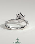 Kynora CJ 2ct round claw solitaire engagement ring with sweeping micropavé band showcasing a sparkling center stone.