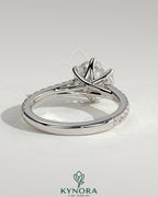 Kynora CJ 2ct round claw solitaire engagement ring with trellis gallery, pave band, and cathedral low setting.