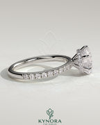 Kynora CJ 2ct round claw solitaire engagement ring with wrap-around hidden halo and pavé band in sterling silver.