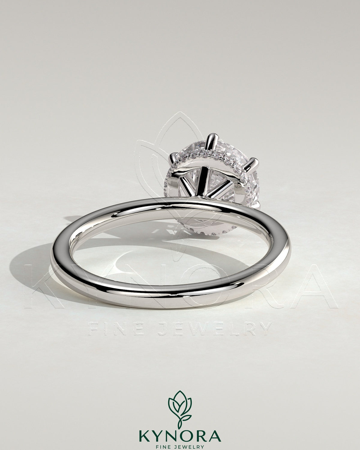 Kynora CJ 2ct round claw solitaire engagement ring with wrap-around hidden halo, showcasing a sparkling diamond setting.