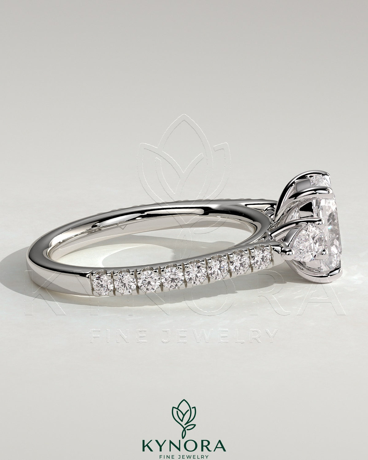 Kynora CJ 2ct elongated cushion trilogy engagement ring with pear side stones and pave band, elegant three-stone design.