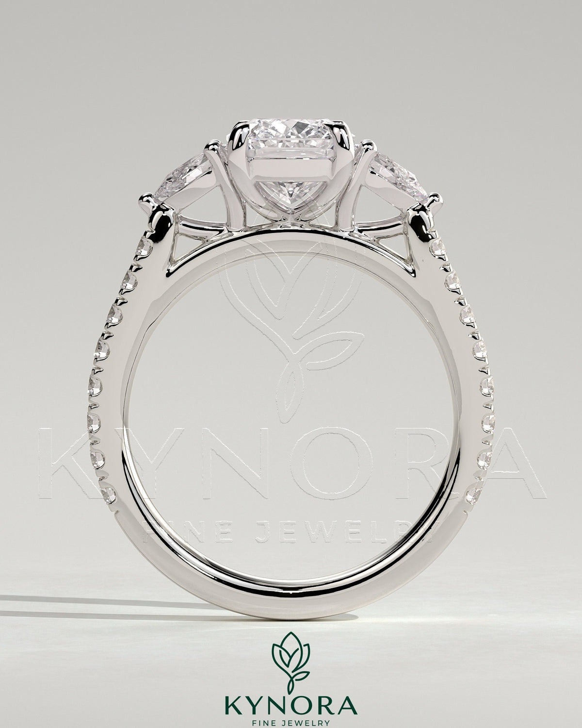 Kynora CJ 2ct elongated three-stone engagement ring with pear side stones and pave band, showcasing elegant diamond design.