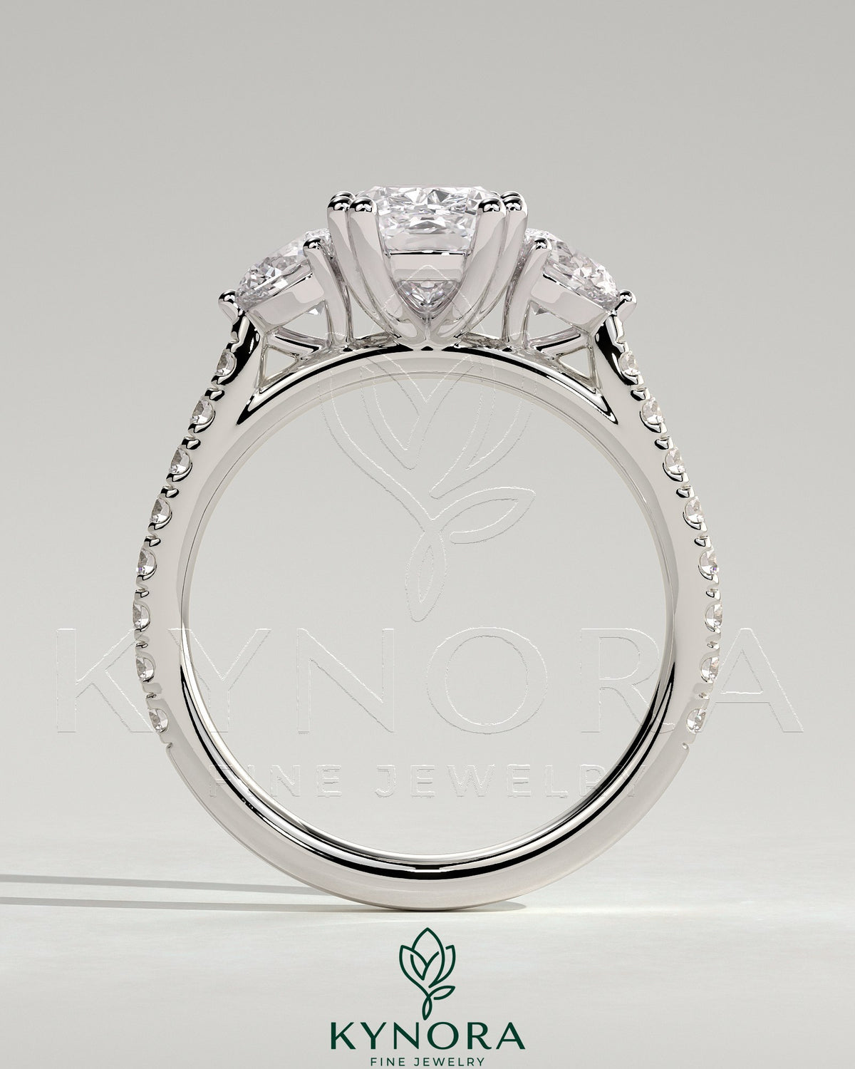 Kynora CJ 2ct elongated cushion double claw trilogy engagement ring with round side stones, pave band, cathedral setting, jewelry image.