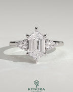 Kynora CJ three-stone engagement ring with 2-carat elongated hexagon center, pear side stones, and cathedral setting.