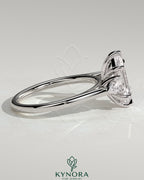 Kynora CJ 2ct elongated hexagon claw trilogy engagement ring with pear side stones and cathedral setting, showcasing intricate design.