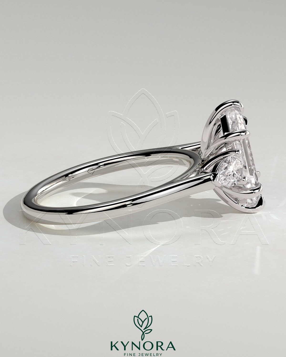 Kynora CJ 2ct elongated hexagon claw trilogy engagement ring with pear side stones and cathedral setting, showcasing intricate design.