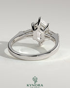Kynora CJ 2ct elongated hexagon claw trilogy engagement ring with tapered baguette side stones and cathedral setting.
