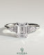 Kynora CJ 2ct emerald claw solitaire engagement ring with pear-shaped accents and round shoulder stones, three stone design.