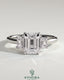 Kynora CJ 2ct Emerald Claw Trilogy engagement ring with emerald side stones and low setting, showcasing a three-stone design.