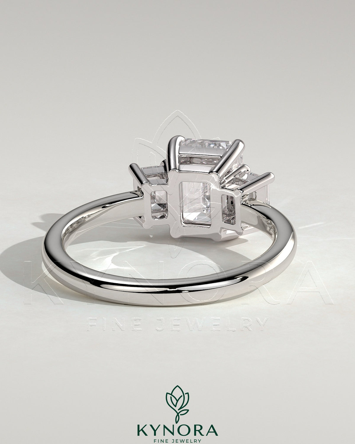 Kynora CJ 2ct emerald claw trilogy engagement ring with emerald side stones and low setting, showcasing fine craftsmanship.
