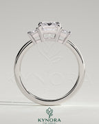 Kynora CJ 2ct emerald claw trilogy engagement ring with emerald side stones and low setting, showcasing elegant craftsmanship.