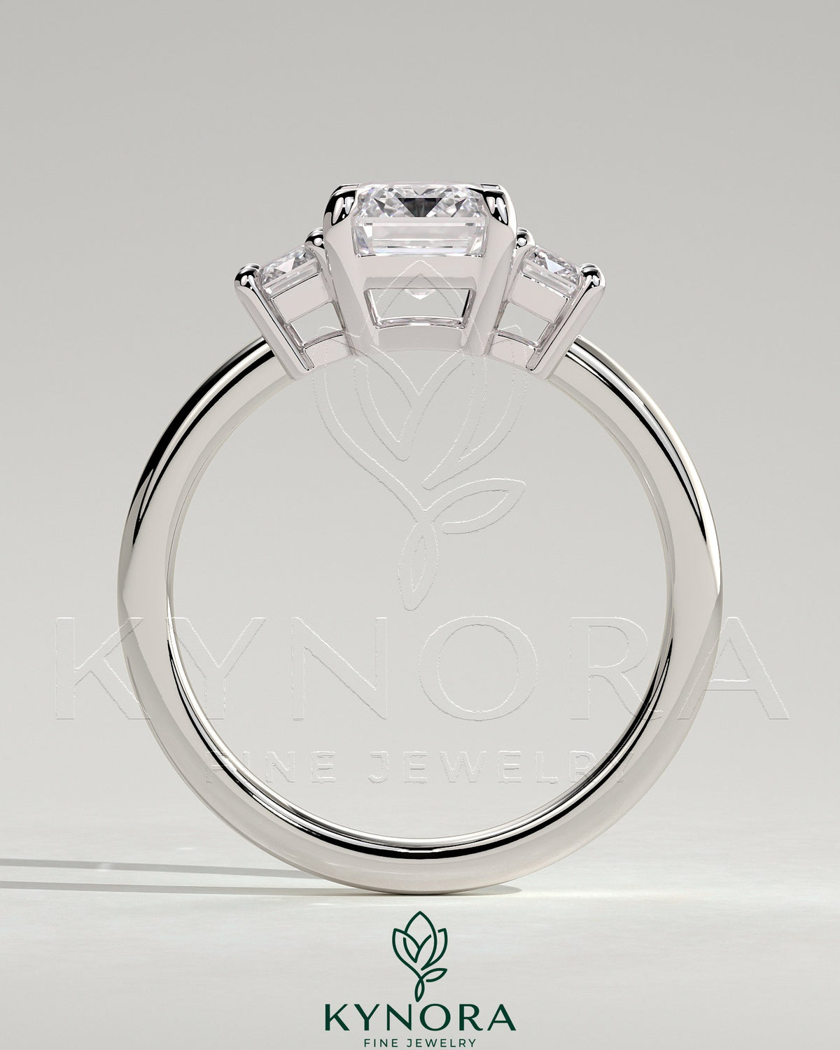 Kynora CJ 2ct emerald claw trilogy engagement ring with emerald side stones and low setting, showcasing elegant craftsmanship.