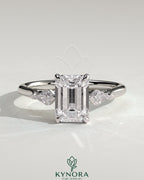 Kynora CJ 2ct emerald claw trilogy engagement ring with kite side stones, featuring a three stone design and detailed craftsmanship.
