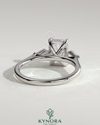 Kynora CJ 2ct emerald claw trilogy engagement ring with kite side stones, featuring a three-stone design and intricate detailing.