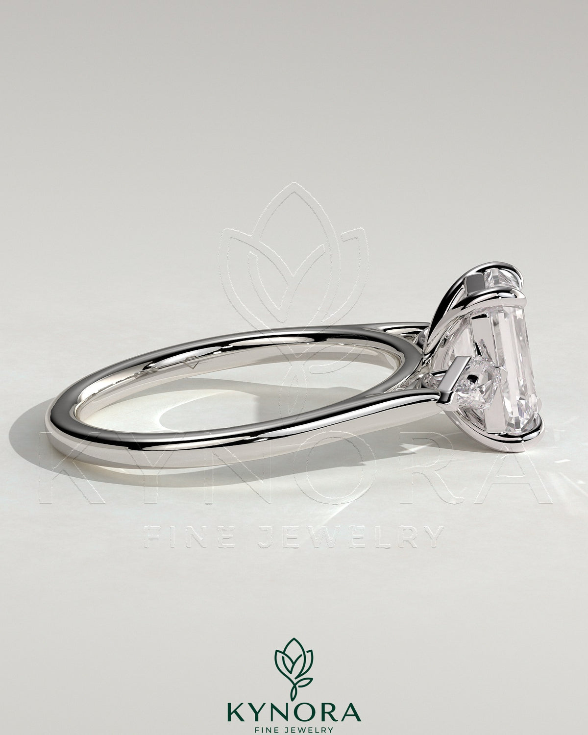 Kynora CJ 2ct emerald claw trilogy engagement ring with kite side stones, showcasing a three-stone design in sterling silver.