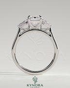 Kynora CJ 2ct emerald claw trilogy engagement ring with kite side stones, featuring a three-stone design and sparkling accents.