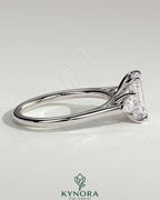 Kynora CJ 2ct emerald claw trilogy engagement ring with pear side stones and cathedral setting, showcasing elegant fine jewelry.