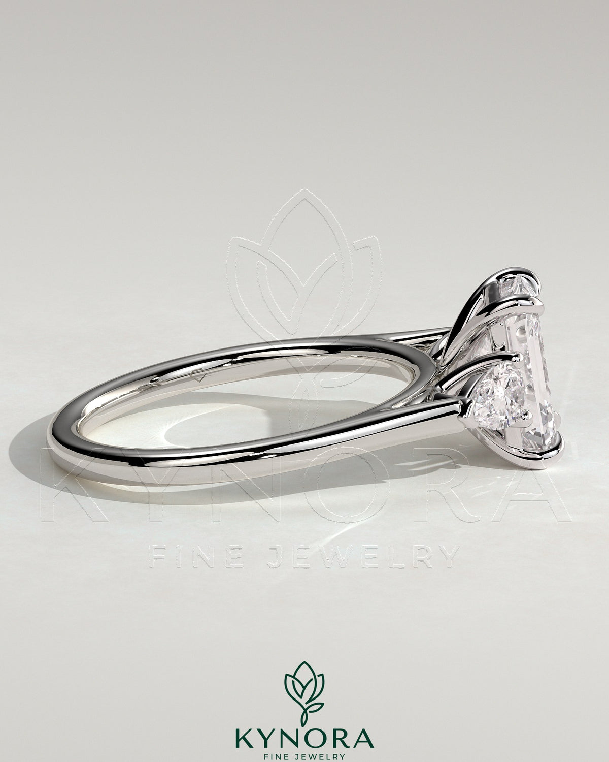Kynora CJ 2ct emerald claw trilogy engagement ring with pear side stones and cathedral setting, showcasing elegant fine jewelry.