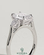 Kynora CJ 2ct emerald claw trilogy engagement ring with pear side stones in cathedral setting, showcasing elegant diamond craftsmanship.