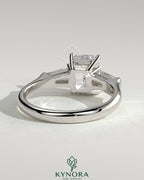 Kynora CJ 2ct emerald claw trilogy engagement ring with tapered baguette side stones in a cathedral setting.