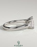 Kynora CJ 2-carat emerald claw trilogy engagement ring with tapered baguette side stones and cathedral setting.