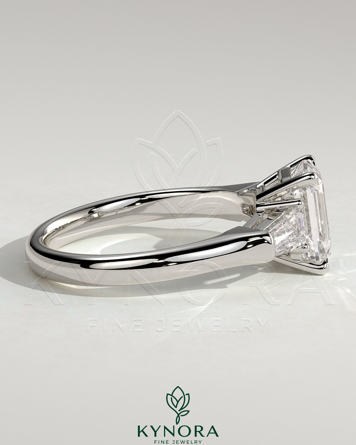 Kynora CJ 2-carat emerald claw trilogy engagement ring with tapered baguette side stones and cathedral setting.