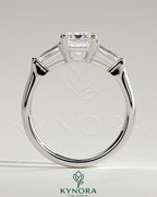 Kynora CJ 2ct emerald claw trilogy engagement ring with tapered baguette side stones and cathedral setting.