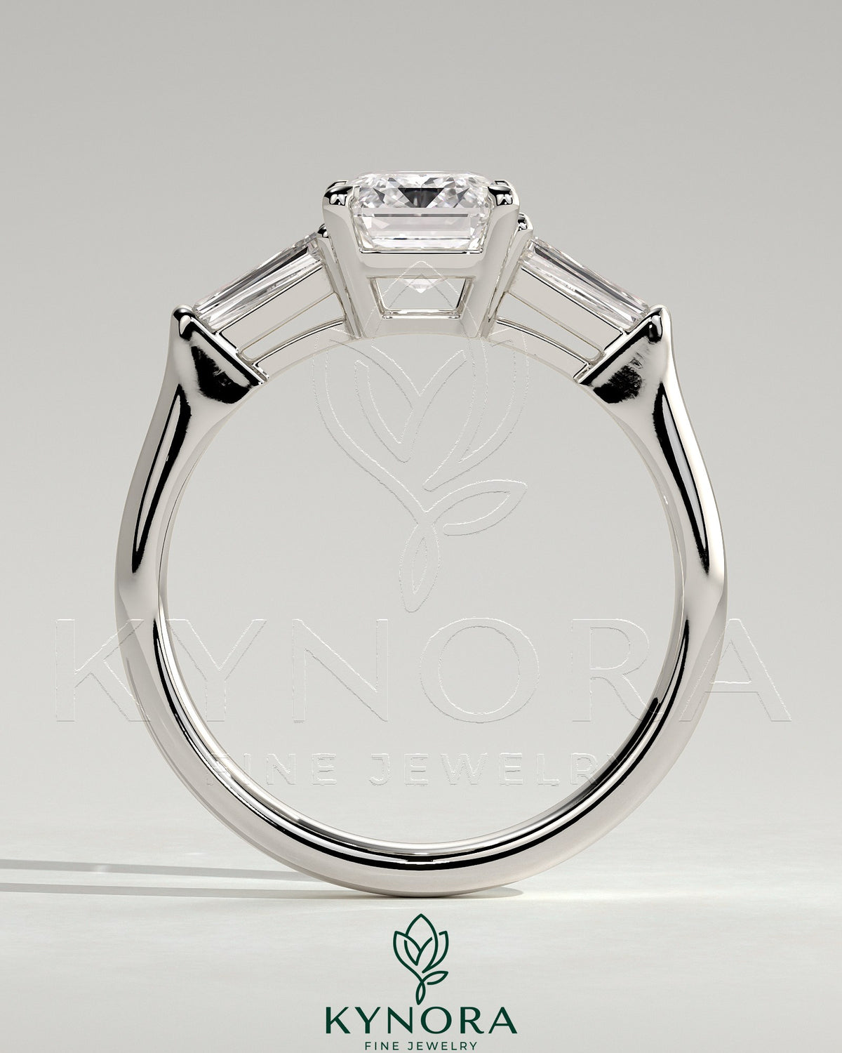 Kynora CJ 2ct emerald claw trilogy engagement ring with tapered baguette side stones and cathedral setting.