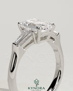 Kynora CJ 2ct emerald trilogy engagement ring with tapered baguette side stones and cathedral setting, showcasing elegant jewelry design.