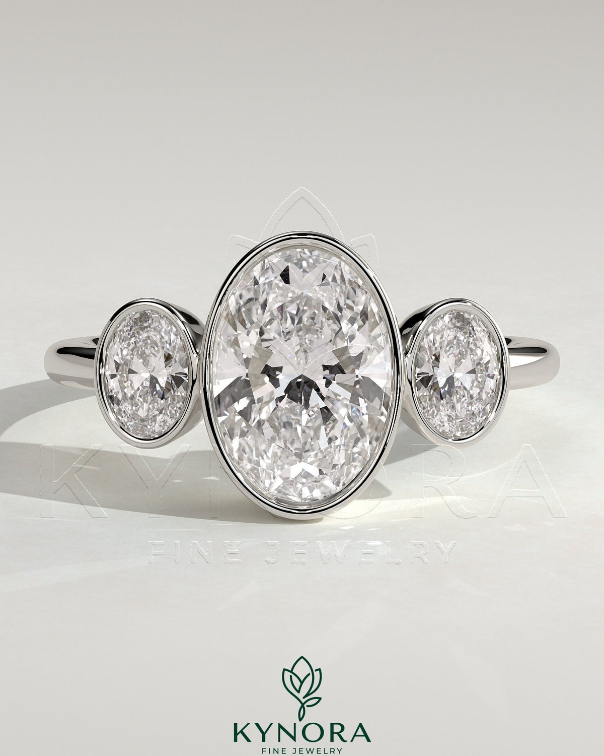 Kynora CJ 2ct oval bezel trilogy engagement ring featuring three sparkling stones set in a sleek band.