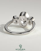 Kynora CJ 2ct oval bezel trilogy engagement ring featuring three sparkling stones set in a sleek band.