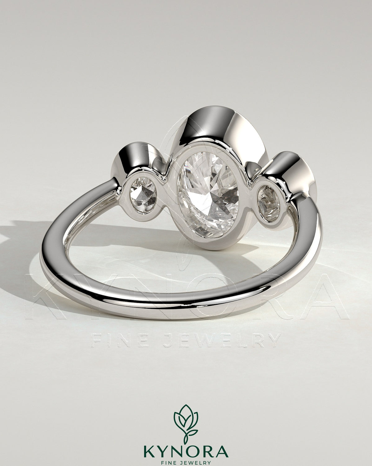 Kynora CJ 2ct oval bezel trilogy engagement ring featuring three sparkling stones set in a sleek band.
