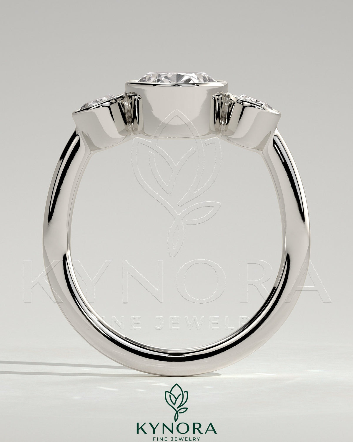 Kynora CJ 2ct oval bezel trilogy engagement ring with three stones and elegant band, showcasing fine craftsmanship and sparkle.