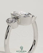 Kynora CJ 2-carat oval bezel trilogy engagement ring with three stones and elegant design, showcasing fine jewelry craftsmanship.